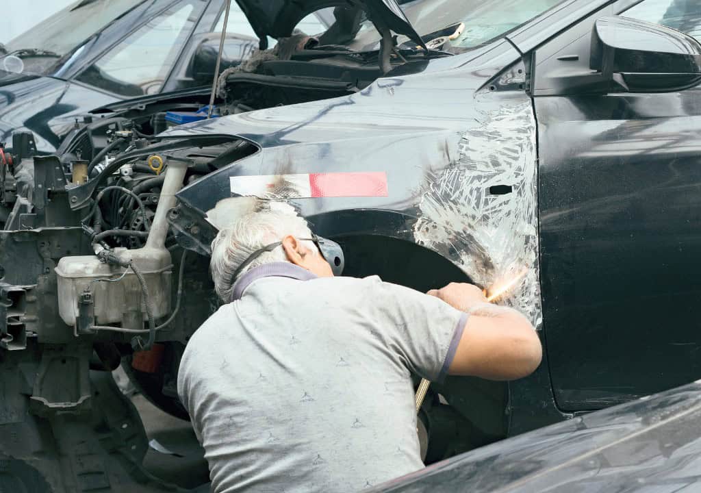 Người đàn ông đang xem tình trạng xe bị nghiêng 1 bên